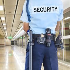 a security officer is standing in the hallway with his hand on a cane and looking at something