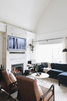 a living room filled with furniture and a flat screen tv mounted on the wall above a fireplace