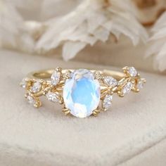 a ring with an oval blue stone surrounded by small white and clear stones on it