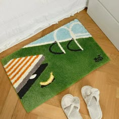 a pair of white slippers sitting on top of a green rug next to a door