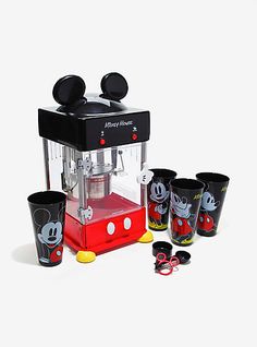 the mickey mouse coffee maker has four cups in front of it