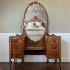 a bedroom with a bed, dresser and mirror