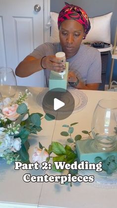 a woman sitting at a table with flowers and candles