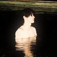 a man standing in the water with his back turned