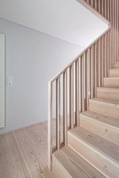 an empty room with wooden stairs and white walls