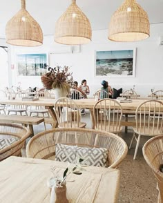 an indoor dining area with wicker chairs and rattan lamps hanging from the ceiling