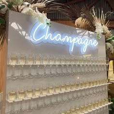 champagne glasses are lined up in front of a large sign that reads champagne on it