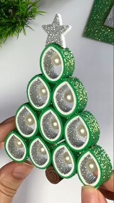 a christmas tree made out of rolled up toilet paper with silver glitters on it