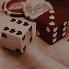 two dices sitting on top of a table next to each other with hearts painted on them