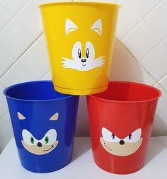 three plastic cups with cartoon faces painted on them