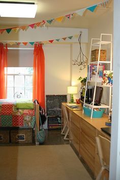 the bedroom is decorated in bright colors and has an orange drape on the window