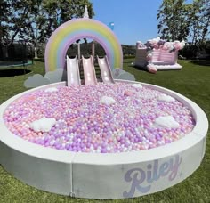 an inflatable pool with pink, purple and white balls floating on it's sides