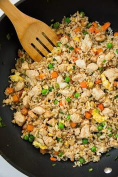 chicken and rice in a skillet with a wooden spoon