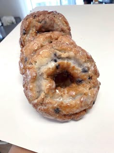 three donuts sitting on top of a white counter