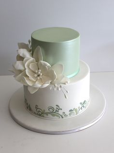 there is a white cake with flowers on the top and bottom, sitting on a plate