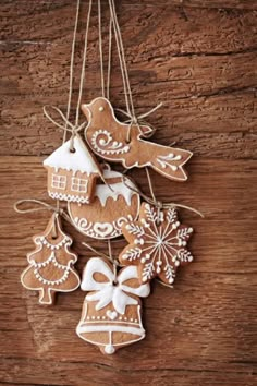 christmas ornaments hanging from strings on a wooden table