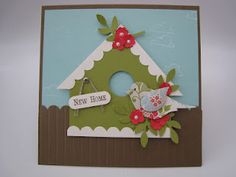 a close up of a card with a bird house on the front and two flowers on the back