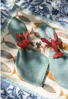 two red lobsters are sitting on some blue fabric