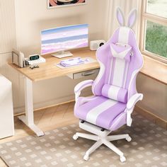 a purple and white computer chair sitting in front of a desk with a monitor on it