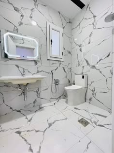 a bathroom with white marble walls and floors