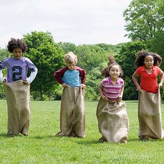 a group of children standing on top of a lush green field next to each other