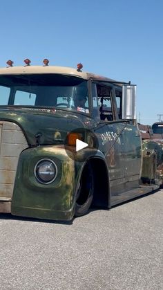 an old green truck parked in a parking lot