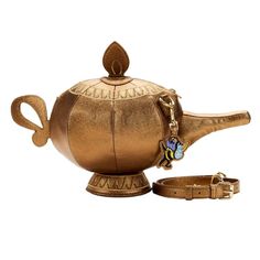 a gold teapot with a key chain around it's neck and the lid is open