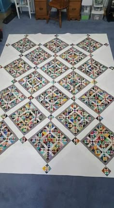 the quilt is laid out on the floor