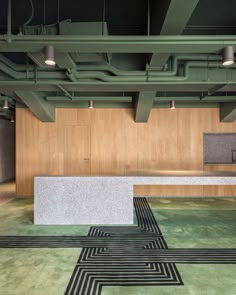 an empty room with black and white lines on the floor, green carpet and wooden walls