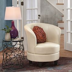 a white chair sitting next to a table with a lamp on it's side