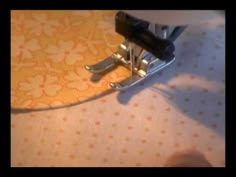 a sewing machine sitting on top of a piece of fabric next to a person's foot