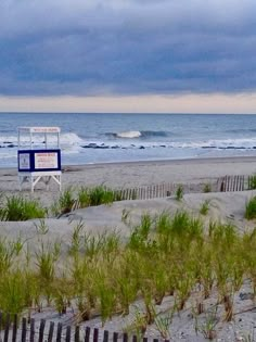 a lifeguard chair on the beach with storm clouds in the background