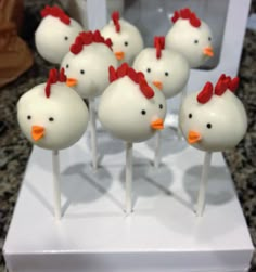 cake pops with white frosting and red bows are arranged in the shape of chickens