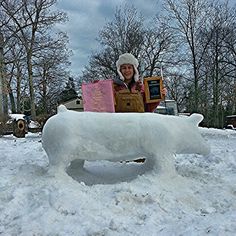 a woman standing in front of a snow sculpture with books on it's back