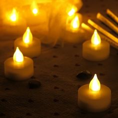 lit candles on a table with rocks and sticks