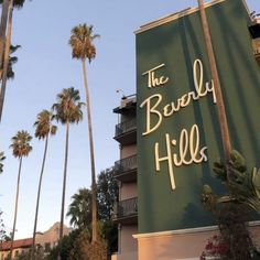 the beverly hills hotel sign with palm trees in the background