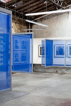 an empty room with blue walls and pictures hanging from the ceiling in front of them