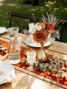 the table is set with plates, silverware and orange napkins for an autumn dinner