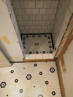 a bathroom with white and black tiles on the floor