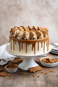 a cake with white icing drizzled over it and cookies on the side