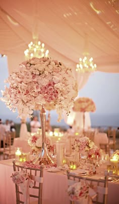 an image of a table setting with flowers and candles in the center for a wedding