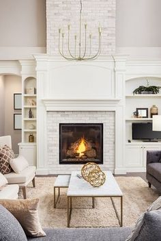 a living room filled with furniture and a fire place in the middle of the room