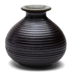 a black vase sitting on top of a white table