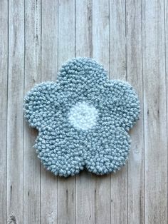 a blue flower shaped rug sitting on top of a wooden floor next to a wall