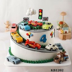 a birthday cake decorated with cars and traffic lights on top of a white platter