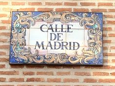 a sign on the side of a building that says calle de madrid in spanish