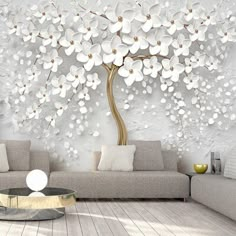 the living room is decorated in white and has a large tree mural on the wall