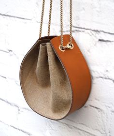 an orange purse hanging on a white brick wall