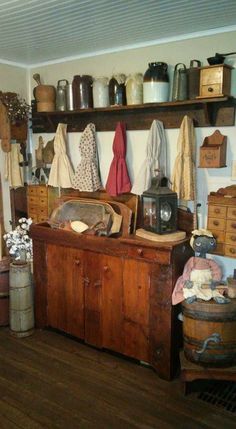 an old fashioned kitchen with wooden floors and shelves filled with pots, pans, and cooking utensils