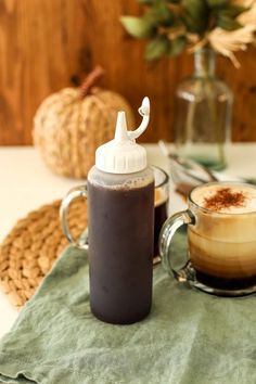 a cup of coffee sitting on top of a green towel next to a glass mug